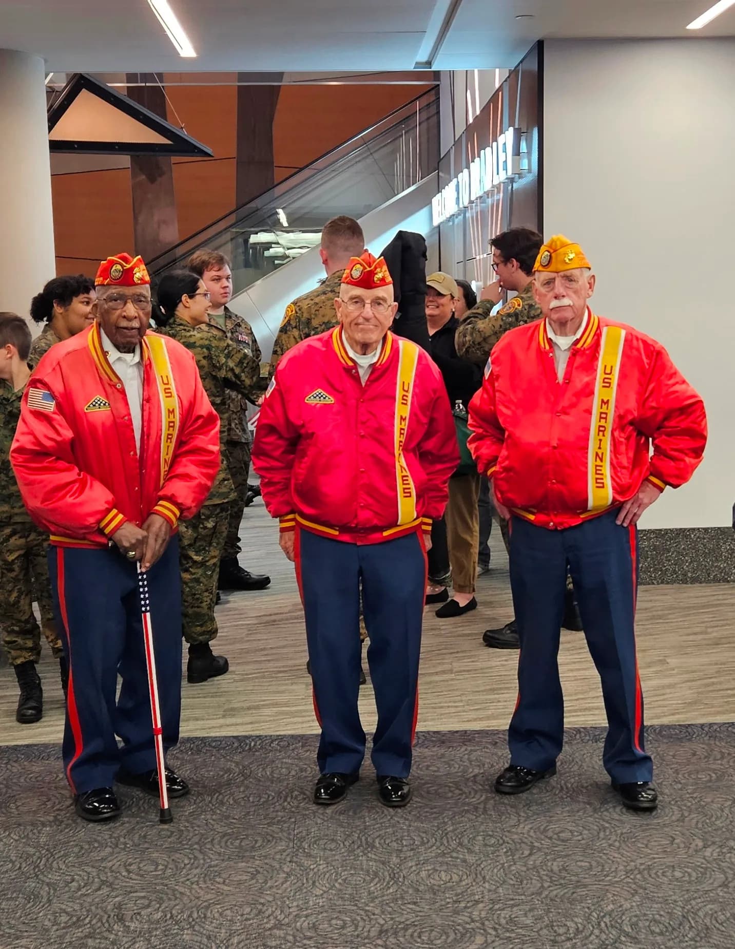 Three U.S. Marine Corps veterans in dress jackets at a welcome-home event