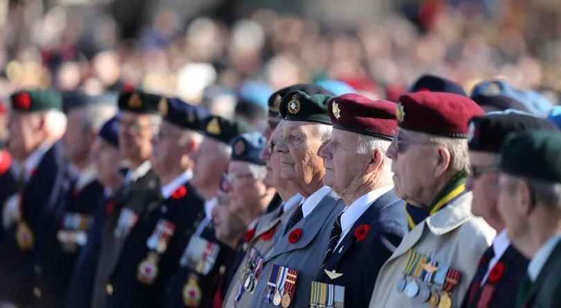 Rows of decorated veterans standing at attention in their service medals